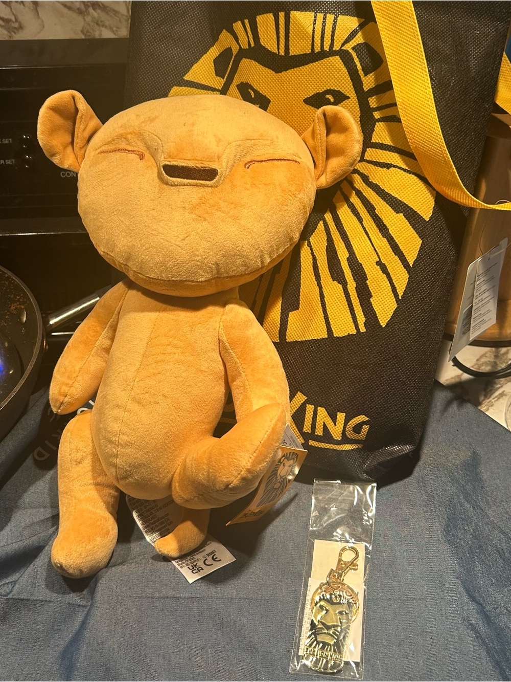 The Lion King the Musical Simba plush, key chain, and tote